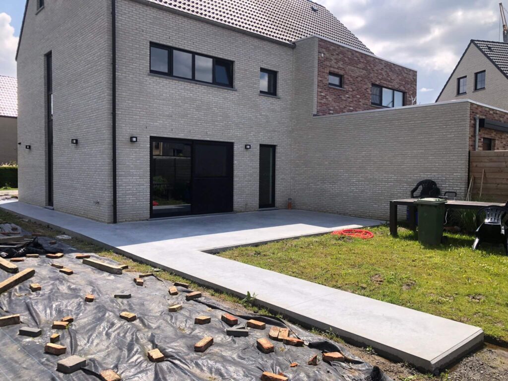 Gepolierde betonnen terras bij moderne woning met pad